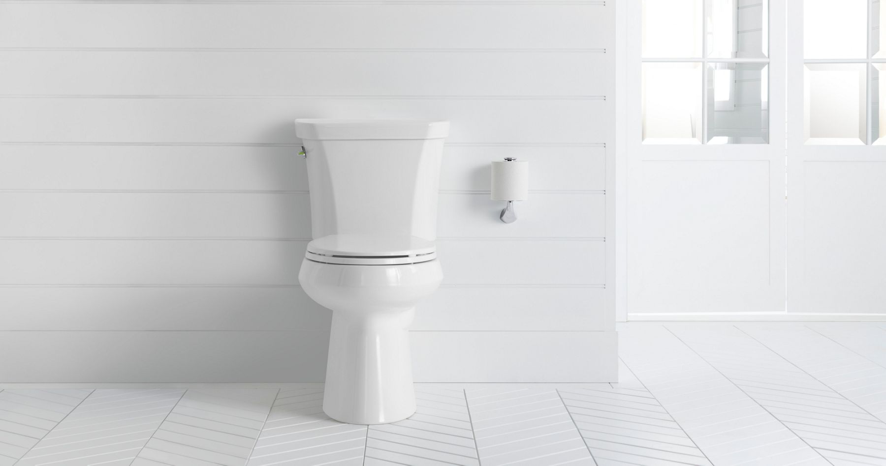Une salle de bain blanche avec une toilette à chasse double allongée blanche Highline de KOHLER.