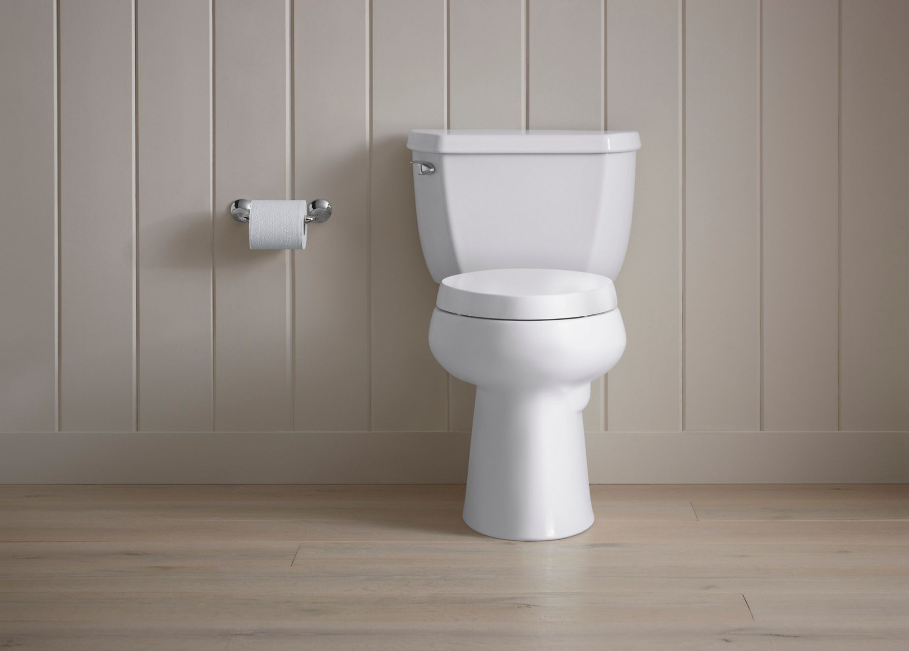 Toilette Comfort-Height Highline KOHLER blanche contre un mur à lamelles blanches.