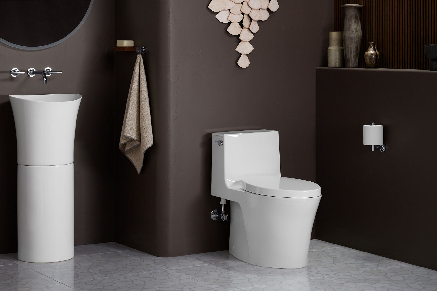 A white KOHLER Veil one-piece compact elongated toilet installed in a brown bathroom.
