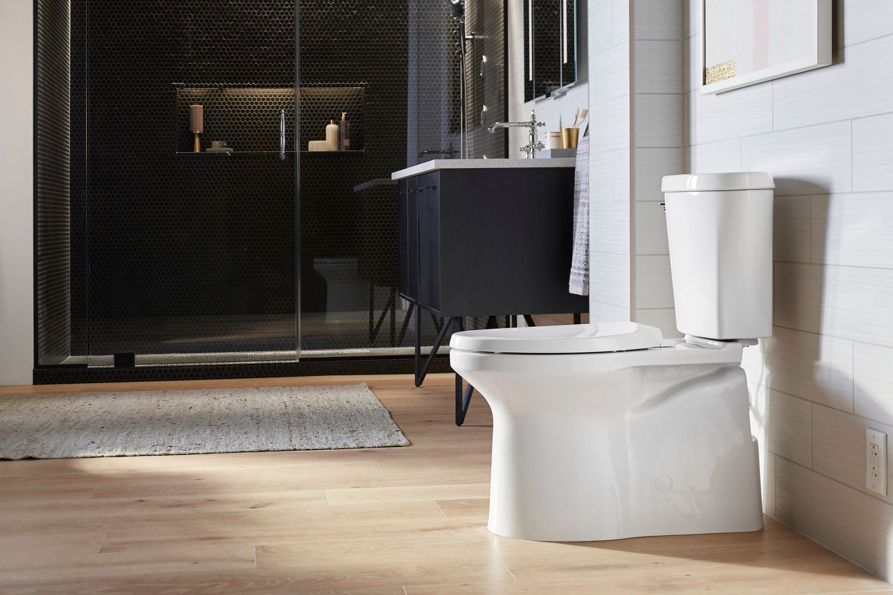 Une salle de bain contemporaine avec une douche de plain-pied, un meuble-lavabo sombre et des toilettes vues de côté.