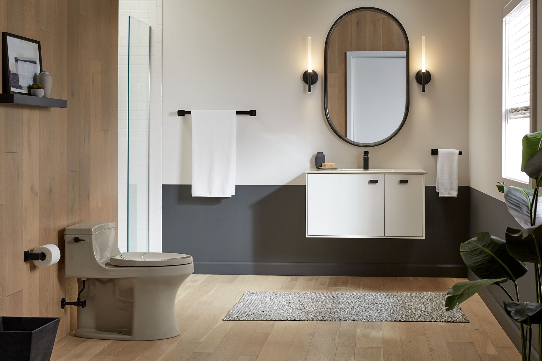 Two Components LED sconce lights beside oval mirror over a white vanity