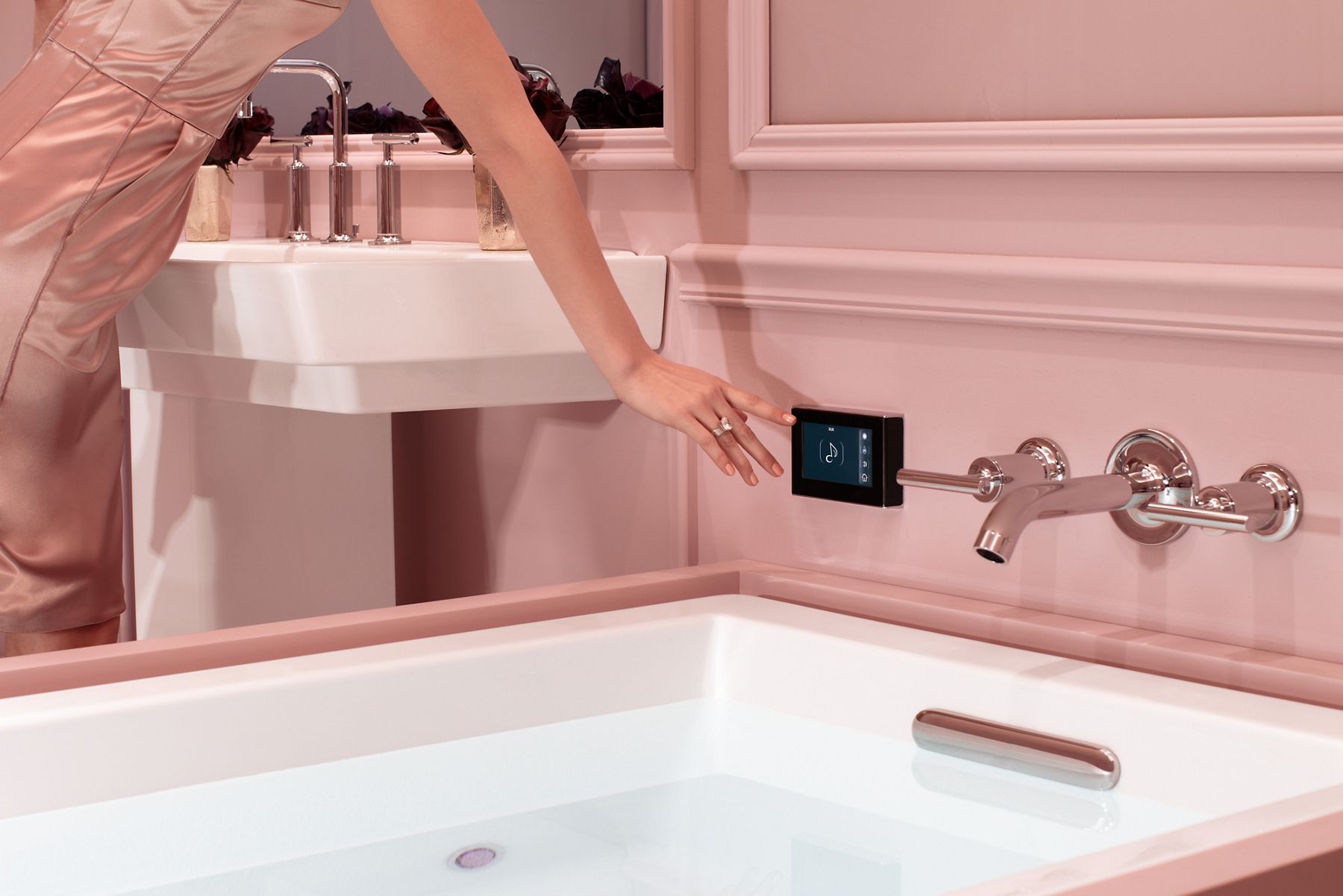 Control panel for bath on pink wall above KOHLER whirlpool tub