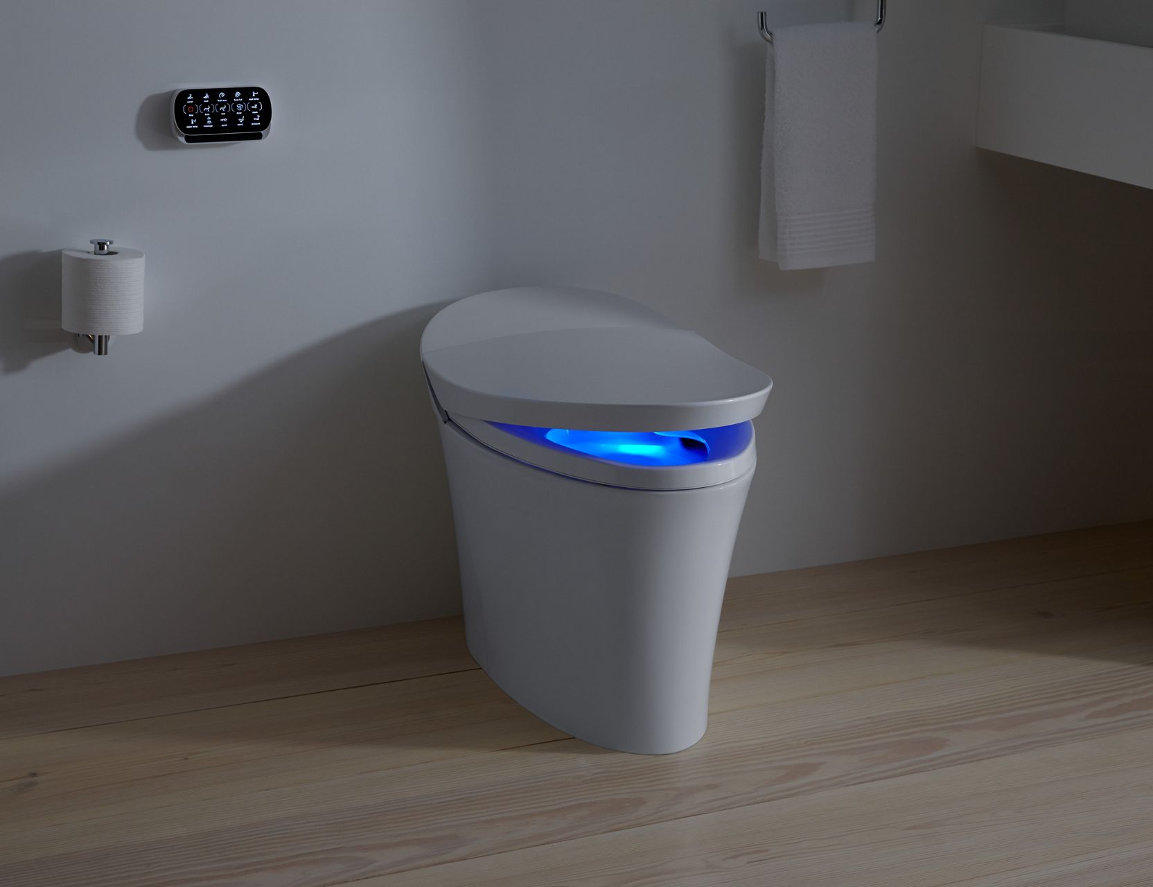 A KOHLER Intelligent toilet in white, with a blue nightlight, installed in a bathroom with marble floors and gray walls.