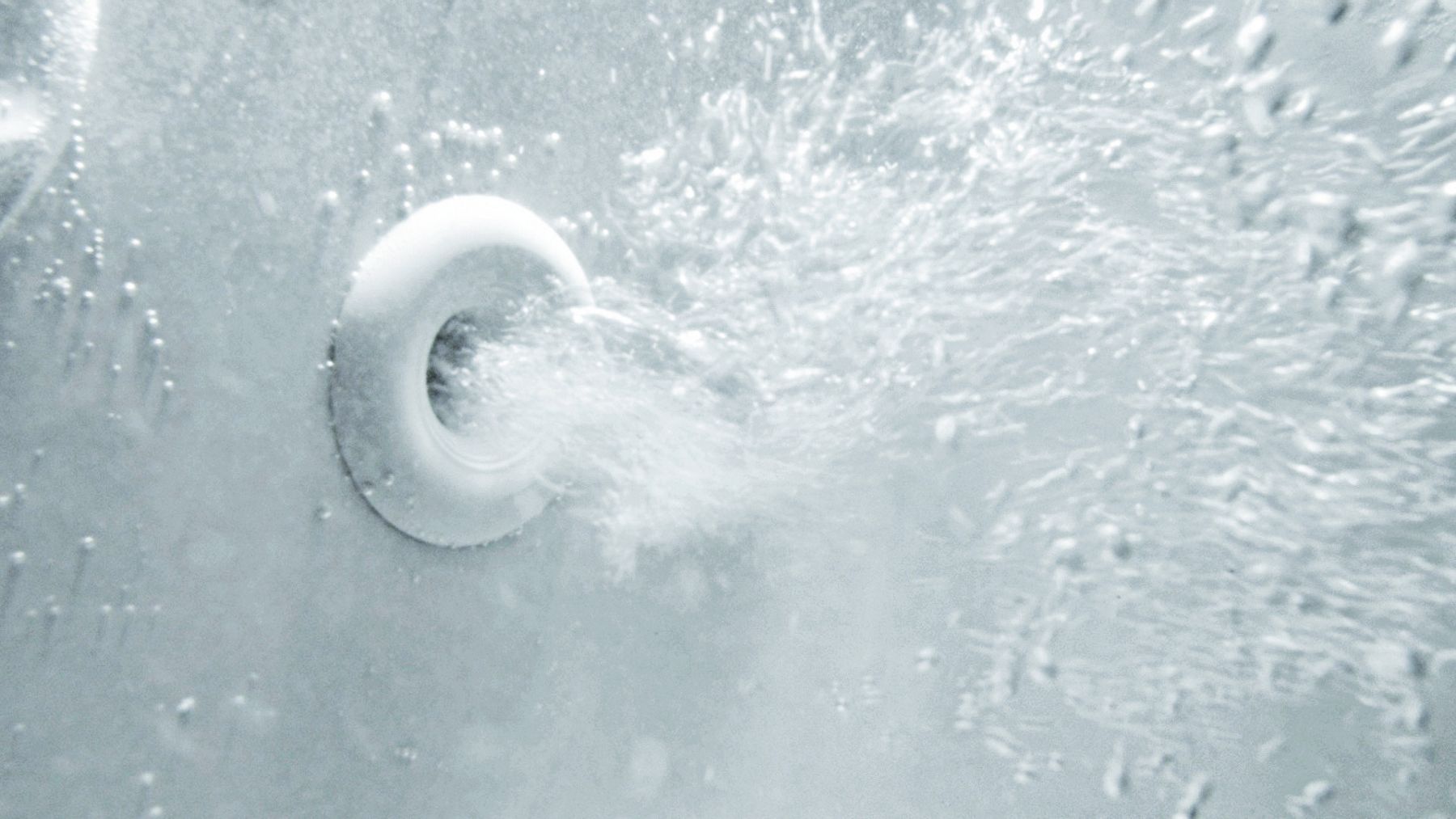 Bubbles emerge from a jet, turning a bathtub into a home spa.