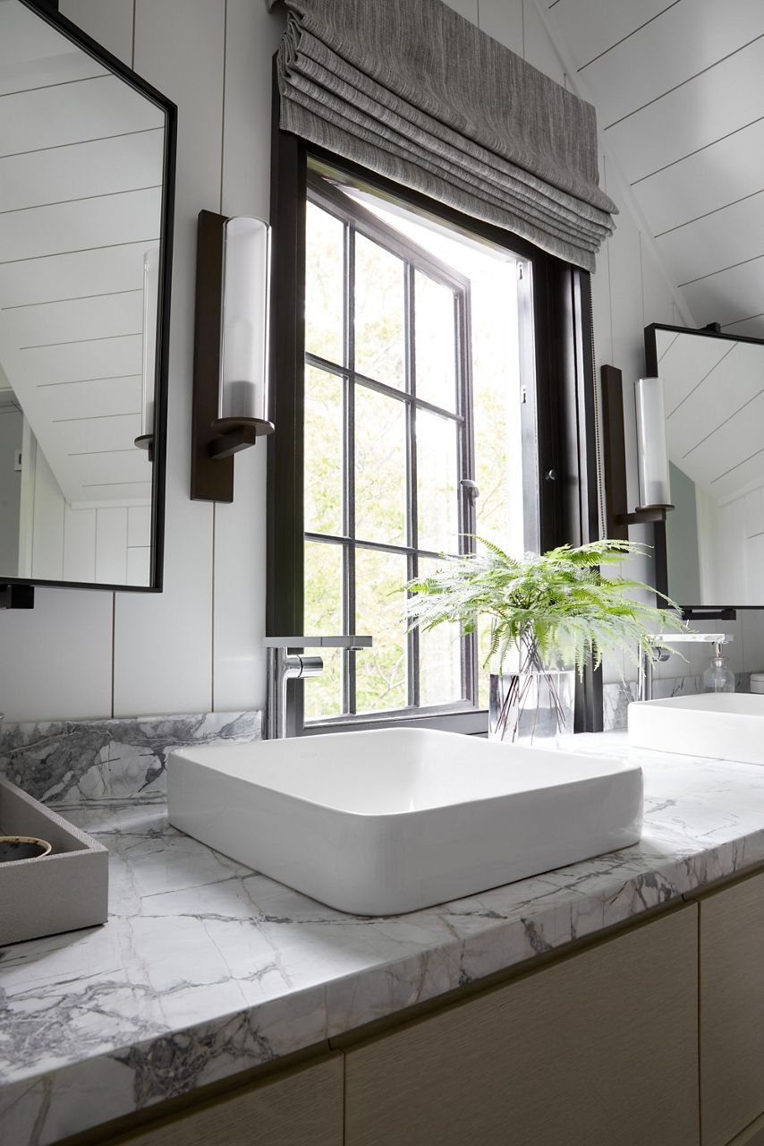 Détail du comptoir de salle de bain avec lavabos en surface rectangulaires blancs.
