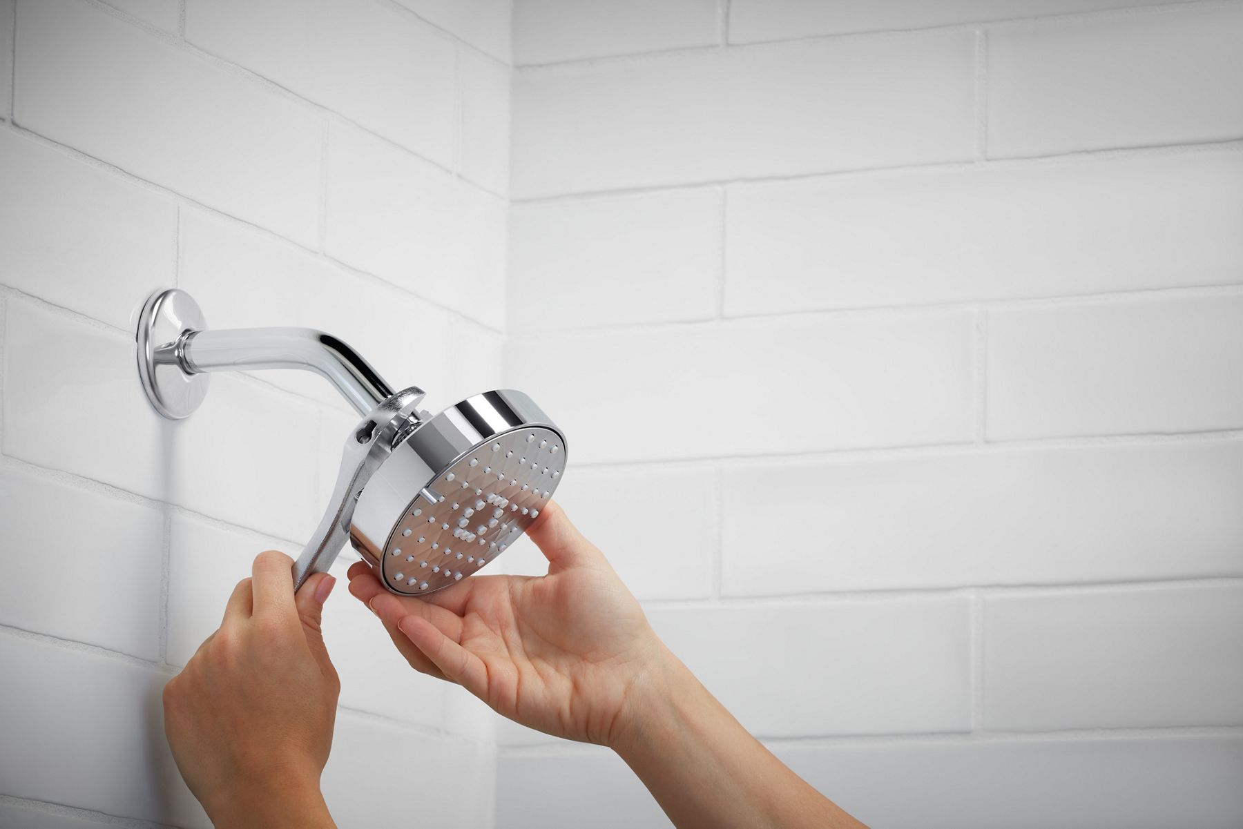 Hands installing KOHLER showerhead with Katalyst technology