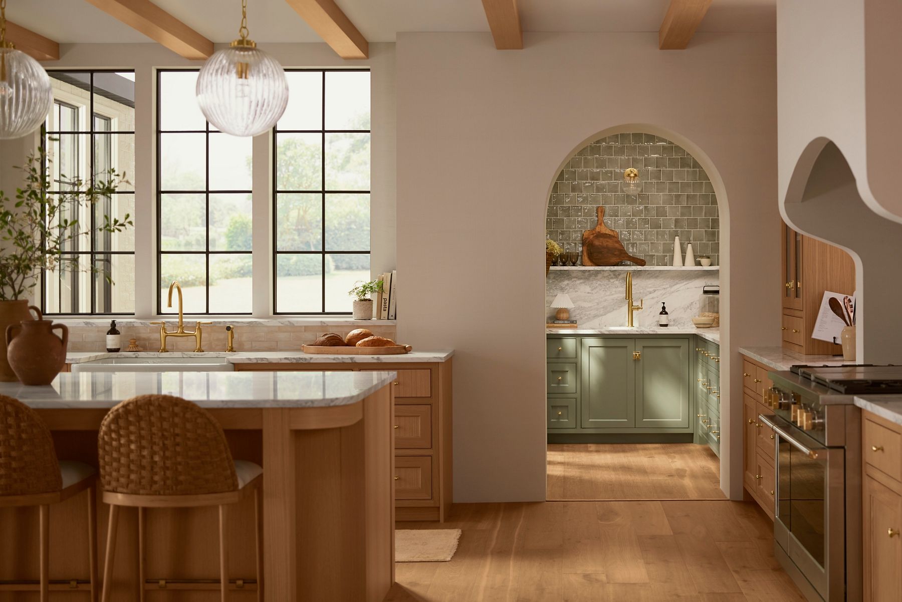 A kitchen in neutral beige and light wood tones with a mint green butler's pantry.