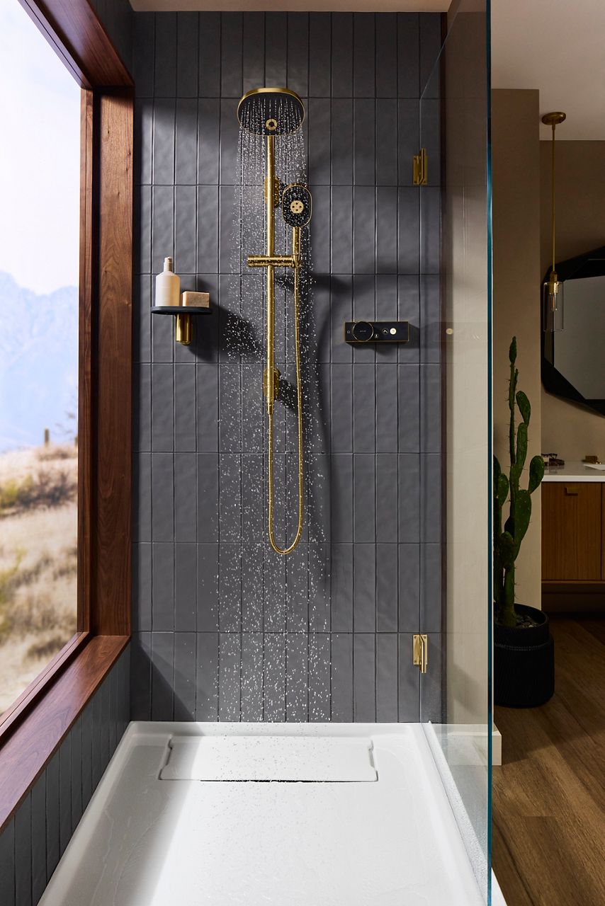 Kohler Anthem EvoCycle smart shower featuring a rainhead, handshower, and digital controller in a modern shower with water flowing from the showerhead.
