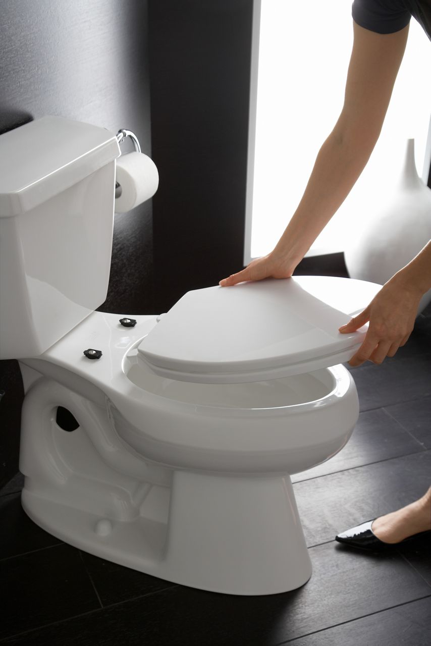 Person attaching a Brevia quick-release toilet seat