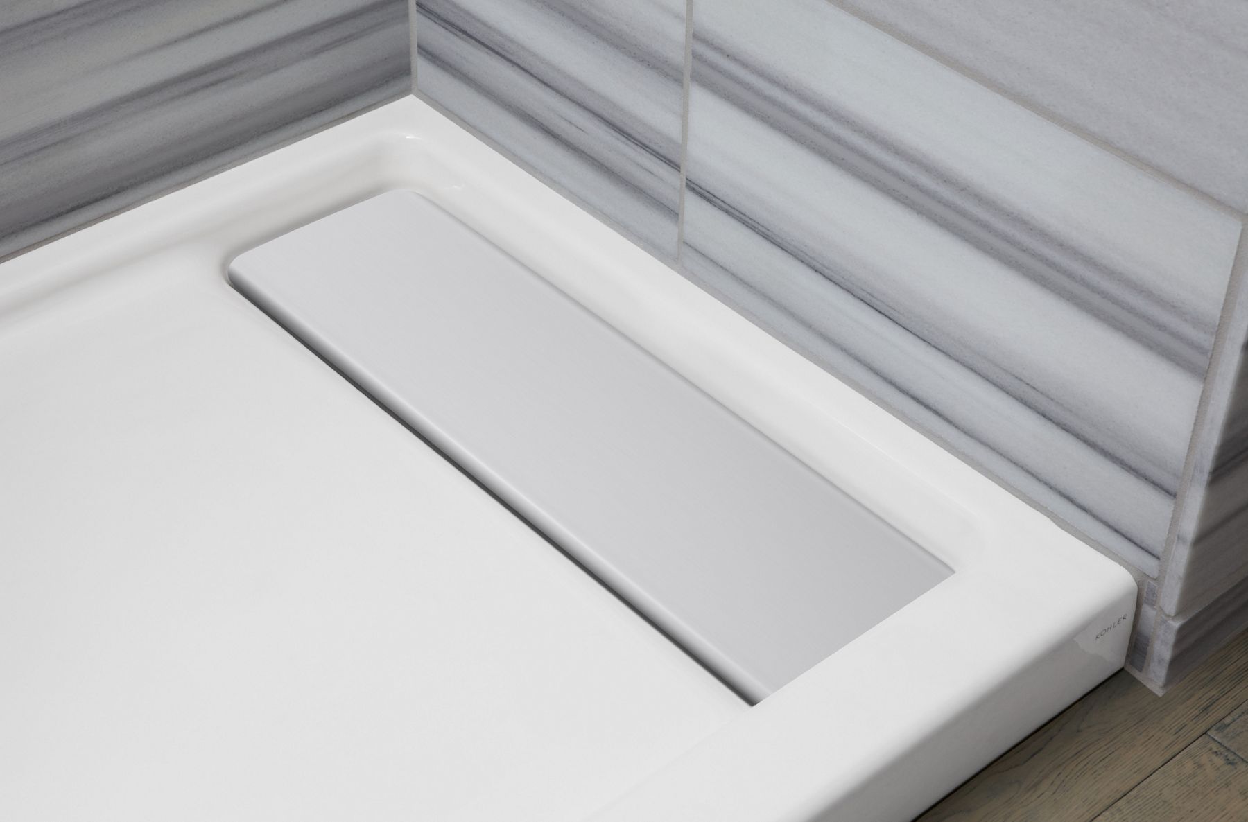 A shower panel with right-hand recessed drain with an aluminum drain cover.