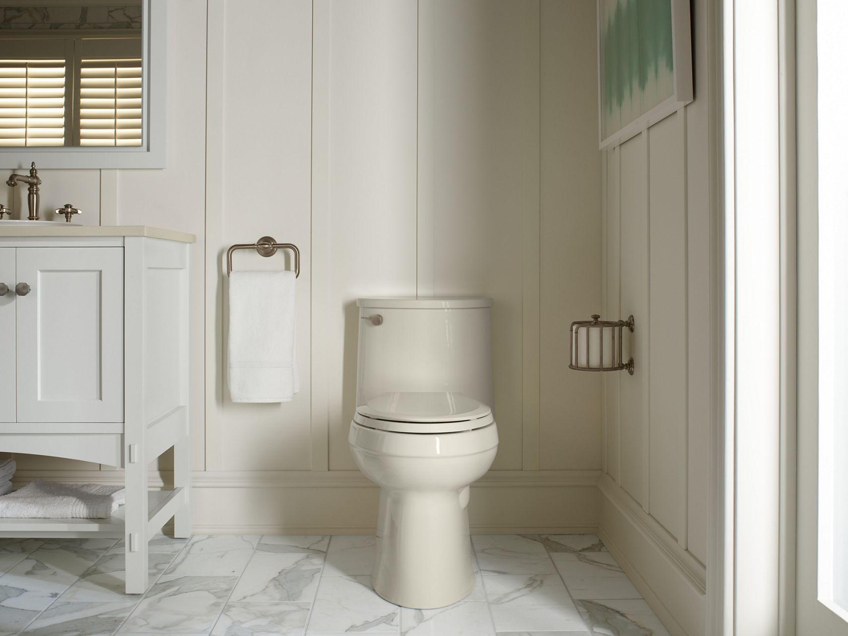 A biscuit-colored transitional toilet in a neutral-colored room.