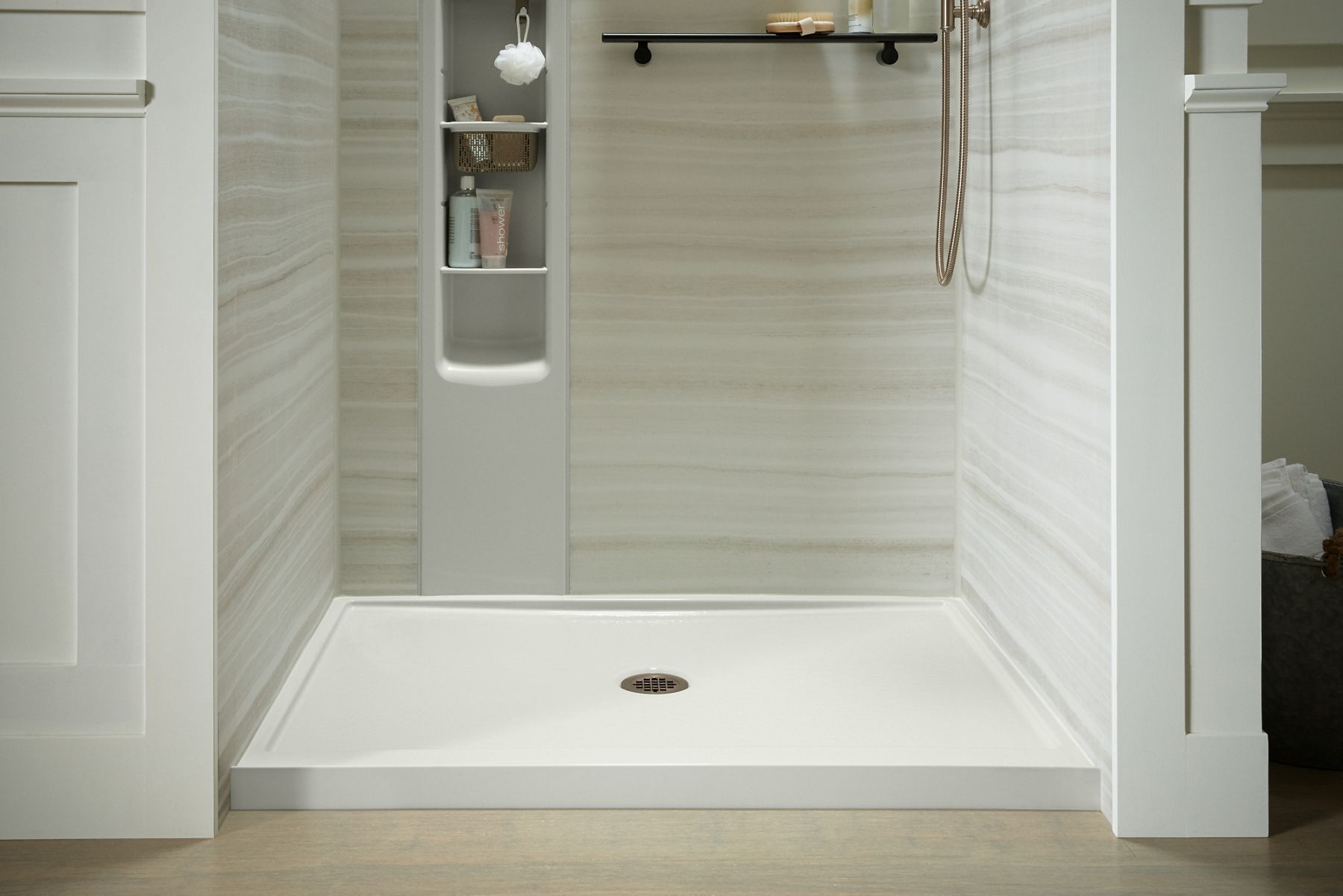 KOHLER Rely shower base with center drain and round drain cover in vibrant brushed bronze.