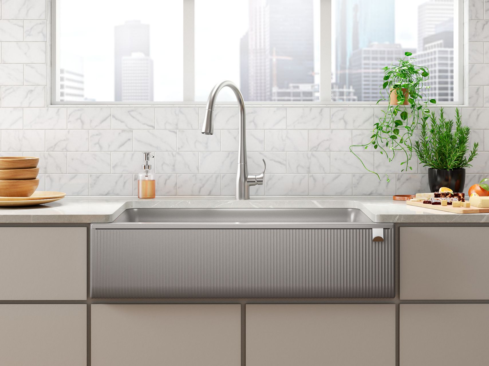 A kitchen with sage green cabinets, white marble counter, pale blue backsplash, white farmhouse sink, and black pull-down faucet.