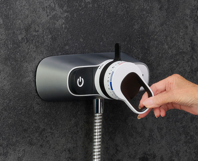 hand on the easy to use shower control button and dial
