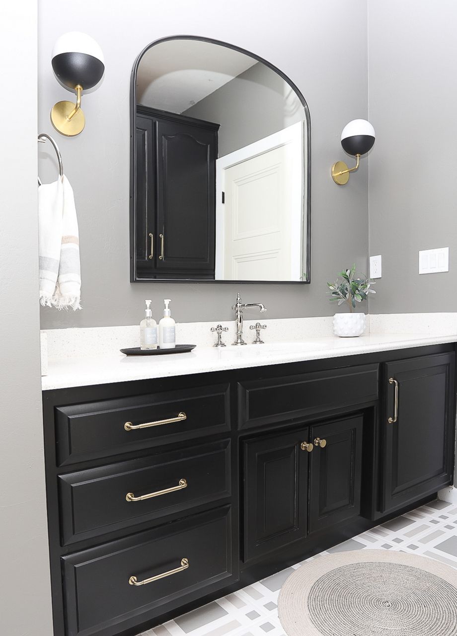 High contrast bathroom with KOHLER light sconces and sink faucet