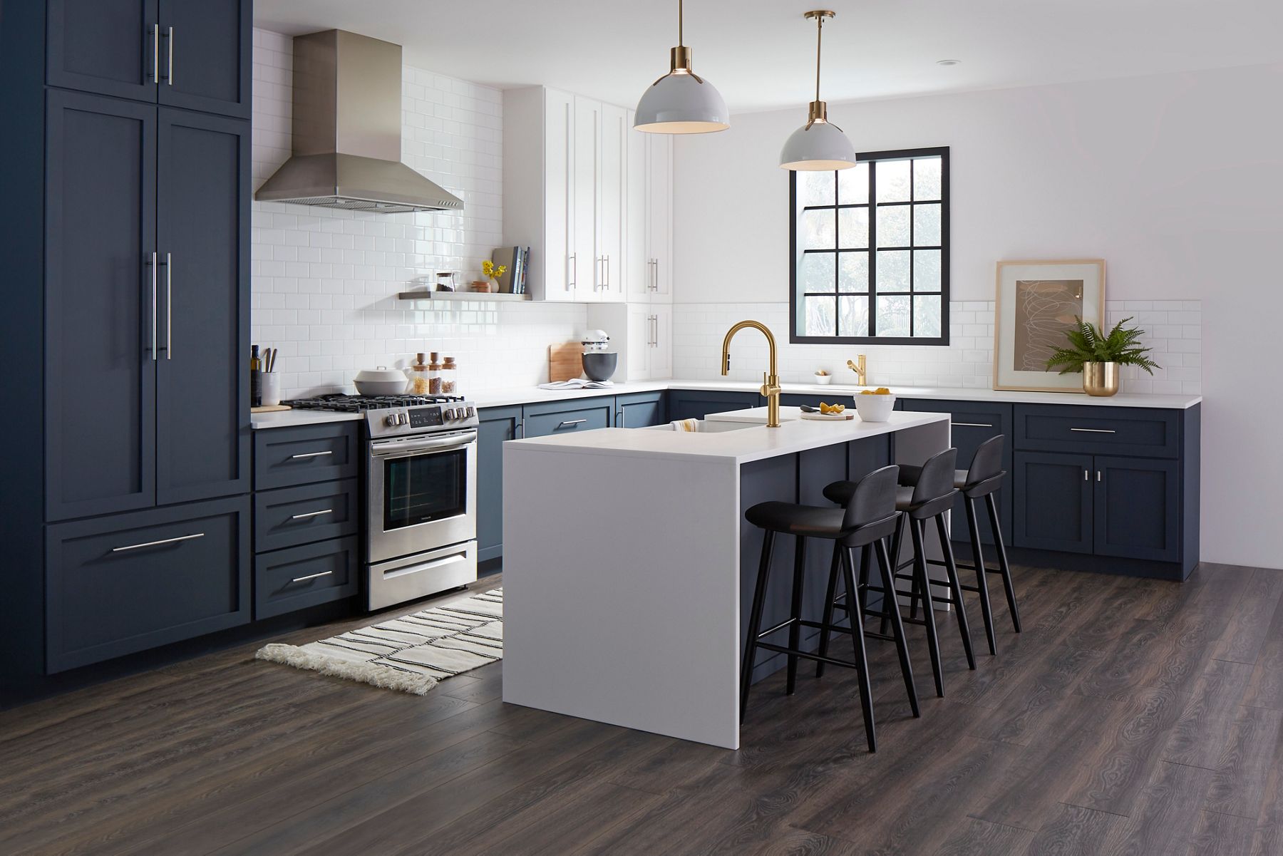 A kitchen in tones of blue and white with an island with seating.