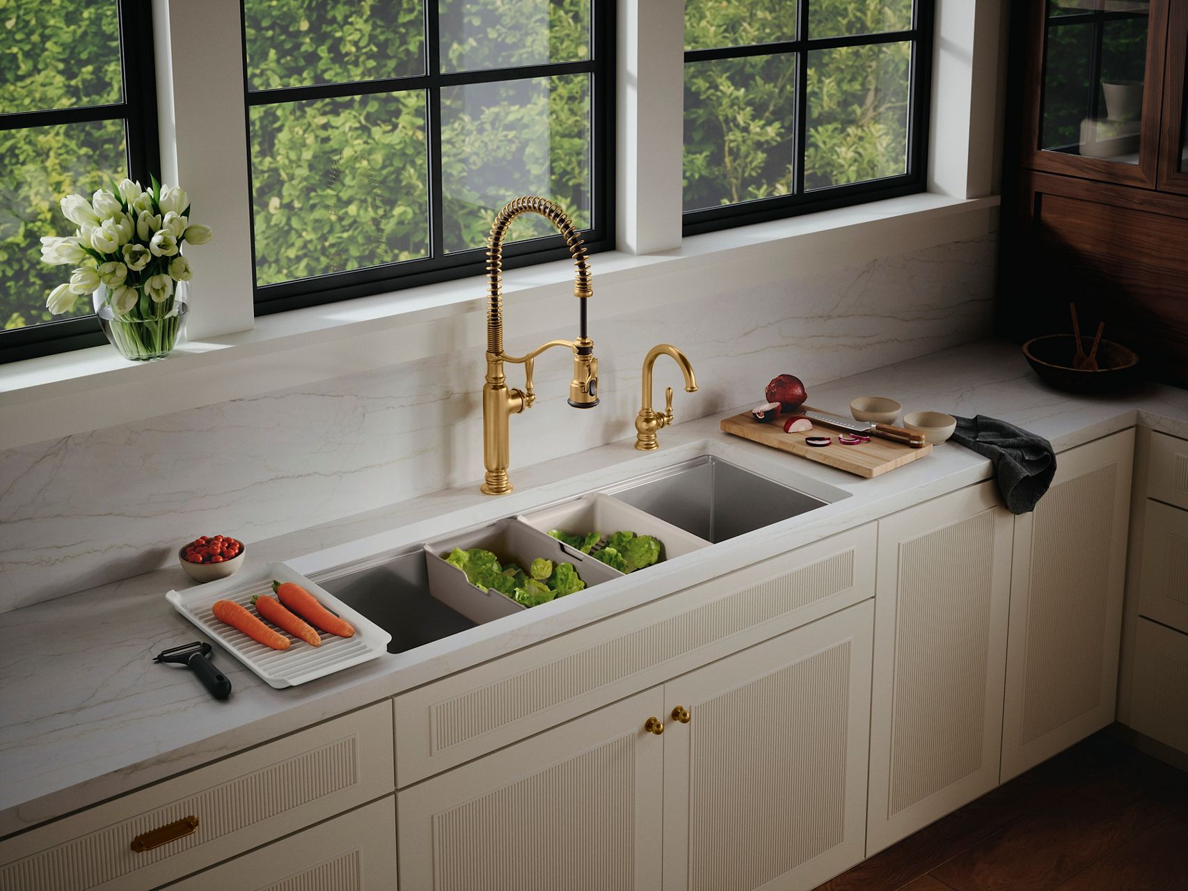 Elegant kitchen setup featuring a dual-faucet design, with one large, industrial-style gold faucet with a spring neck and a smaller matching faucet. Below the faucets, the sink contains neatly organized vegetables, and a cutting board with sliced onions is nearby. The countertop is a smooth, white marble, and a large window offers a view of greenery outside.