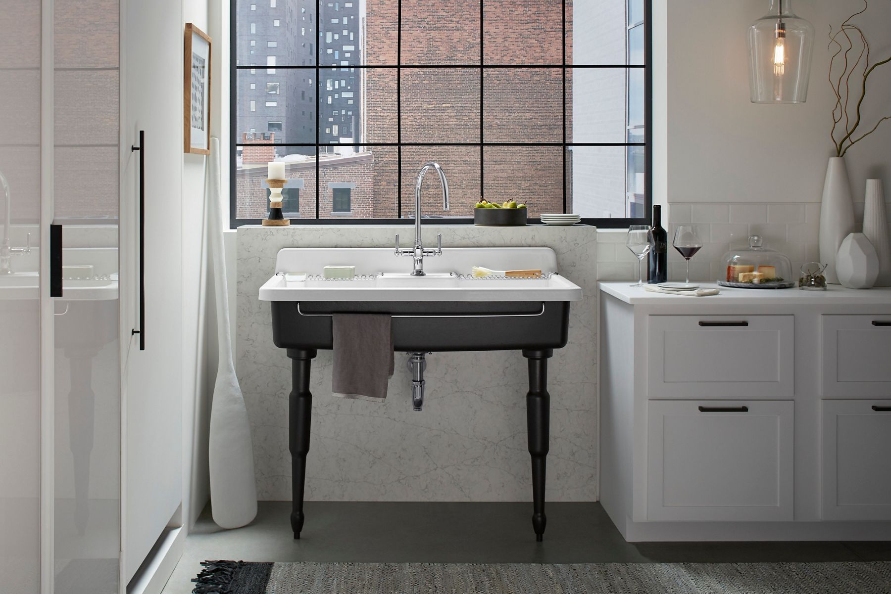A kitchen with a white walls, cabinets, and island with a wood-grain cabinet to the side.