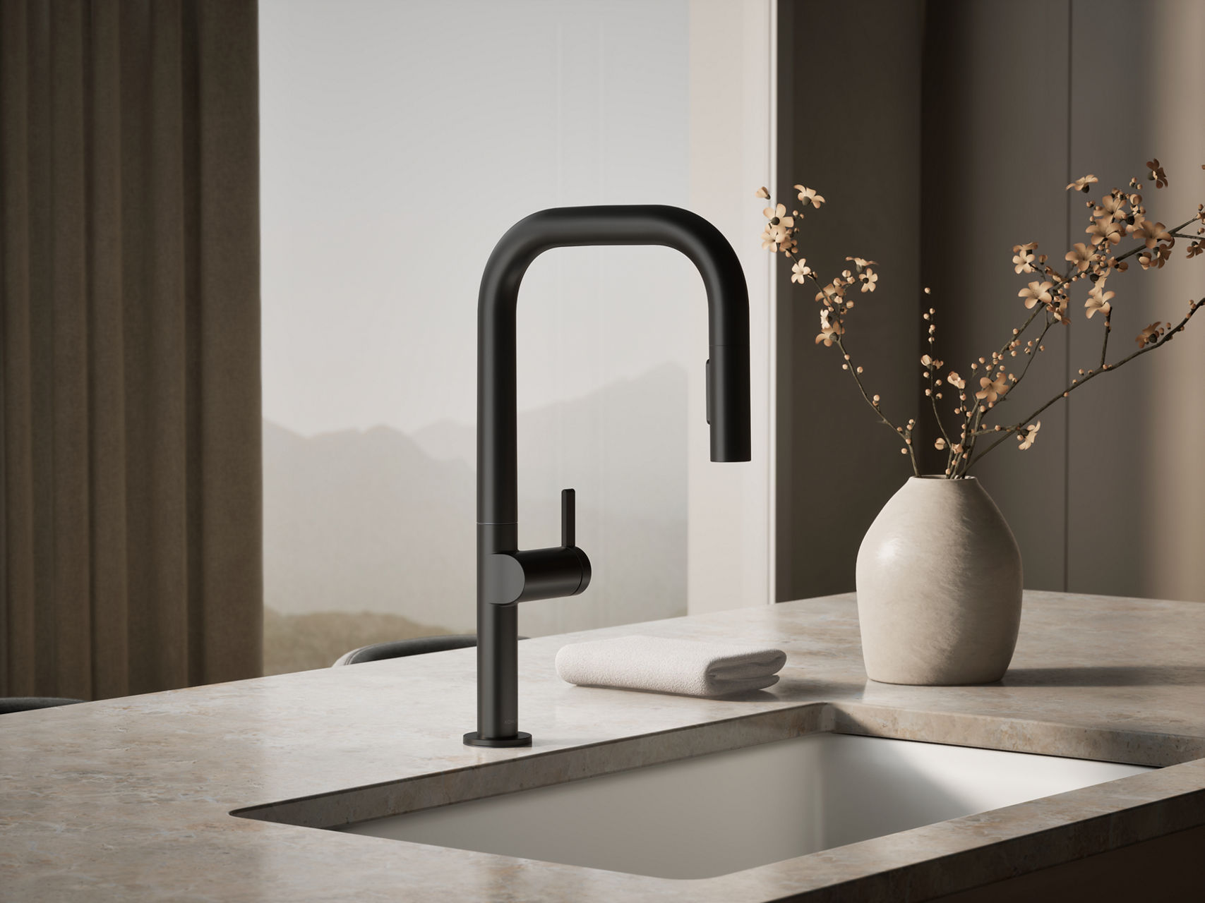 Modern matte black pull-down kitchen faucet installed on a stone countertop beside a minimalist vase with branches.