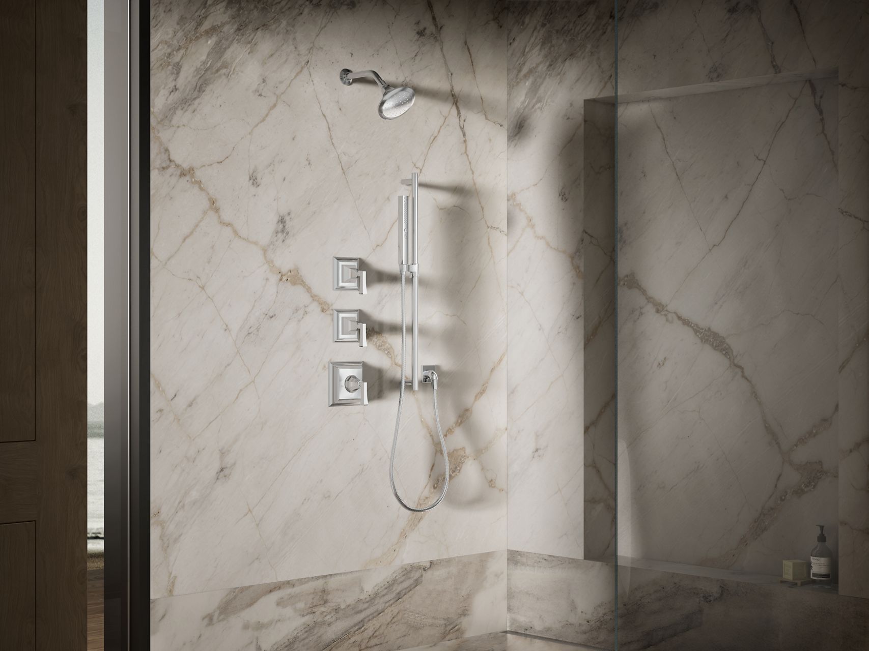 Claude collection shower system featuring a rainhead, handshower, and integrated controls mounted on marble walls within a luxurious walk-in shower.