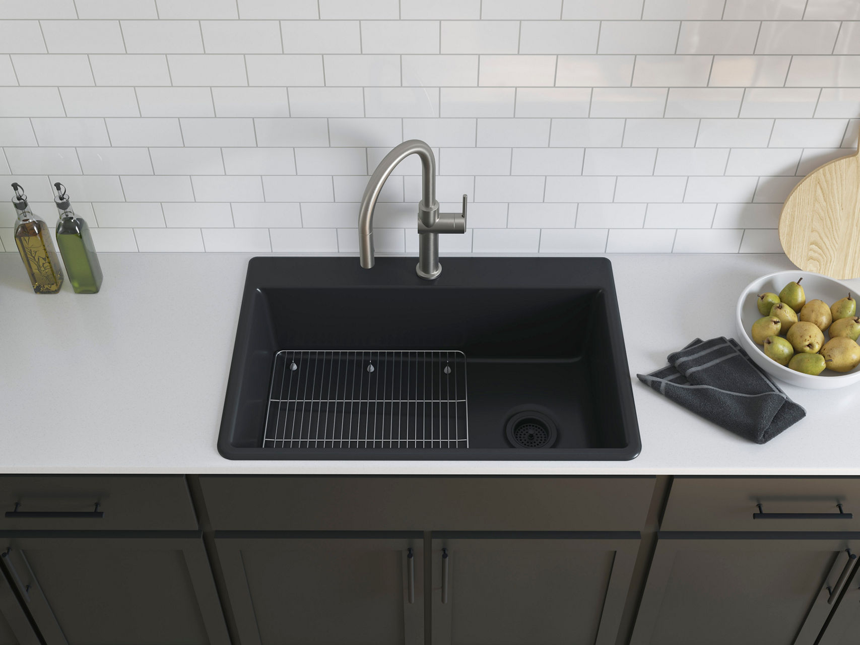 Contemporary matte black sink set into a white subway tile backsplash with a matching black faucet and gold-accented accessories.