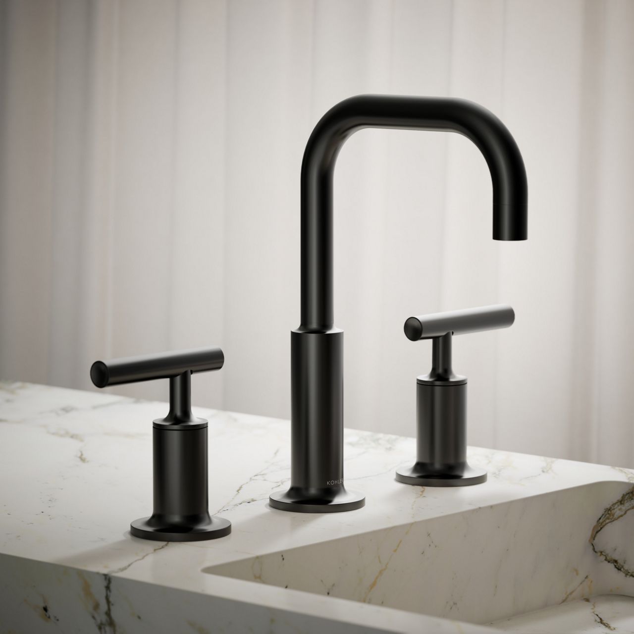 Close-up of a matte black widespread bathroom faucet installed on a white marble vanity with subtle gold veining.
