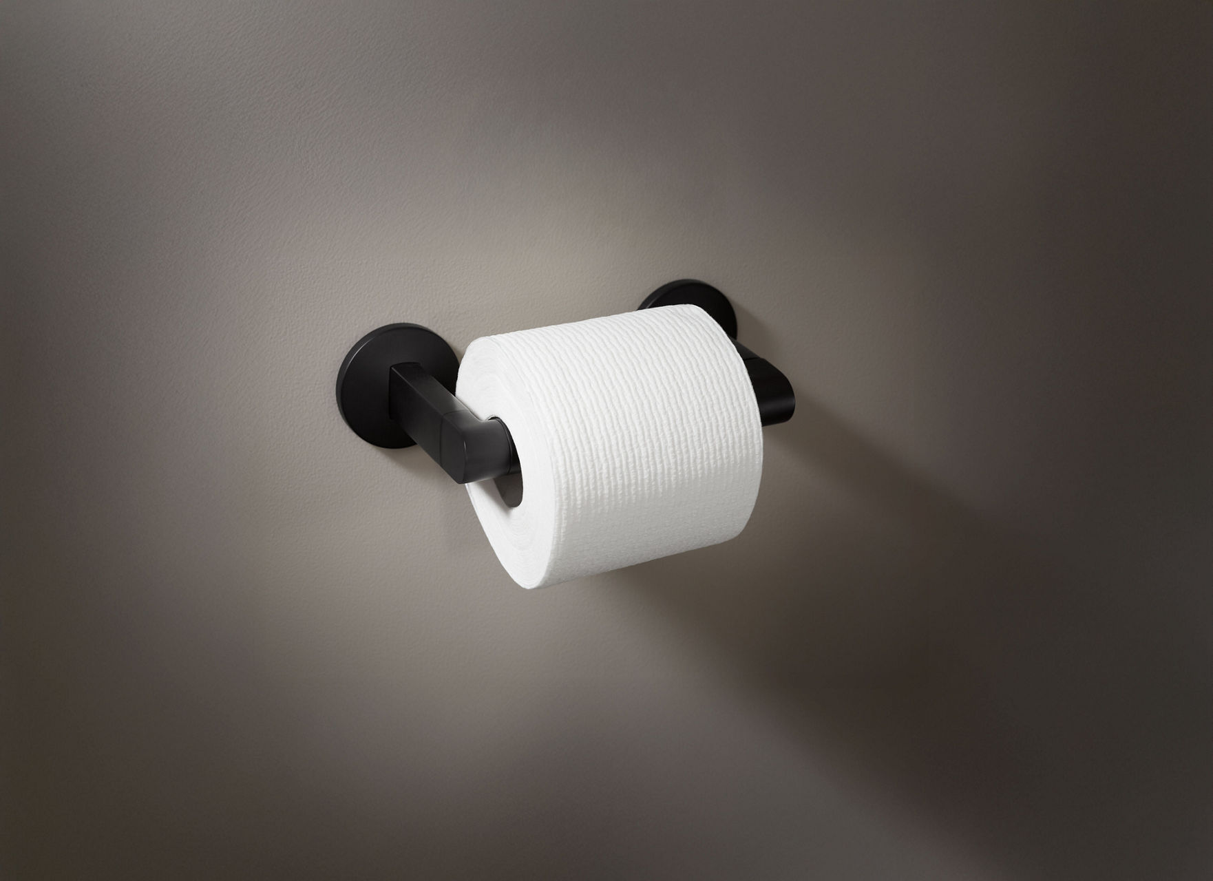 Contemporary matte black wall-mounted toilet paper holder with a single roll.
