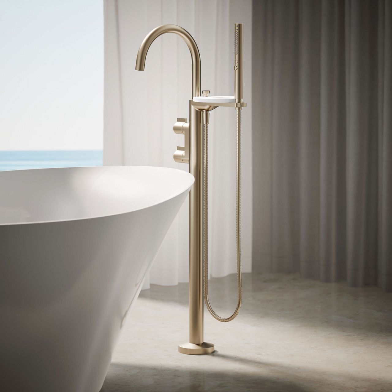Freestanding brushed gold bathtub filler with handshower positioned beside a white soaking tub in a contemporary bathroom.