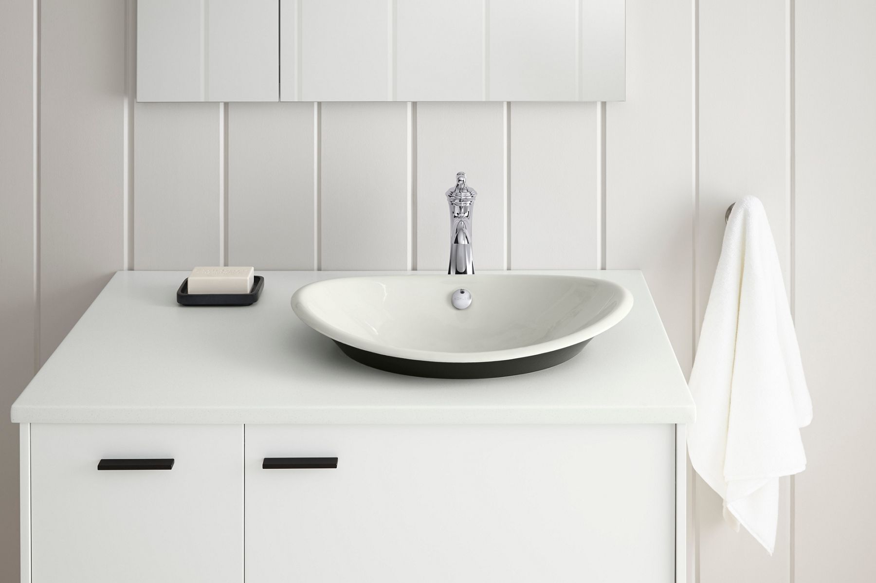 Minimal white bathroom vanity with round vessel sink, chrome faucet, and vertical wall panel detailing
