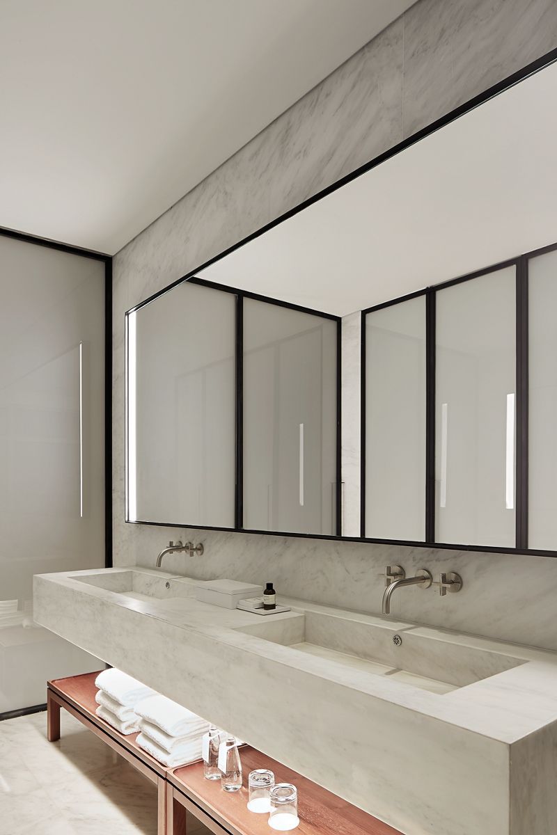 A hotel guest bathroom with KOHLER wall-mounted sink faucets.