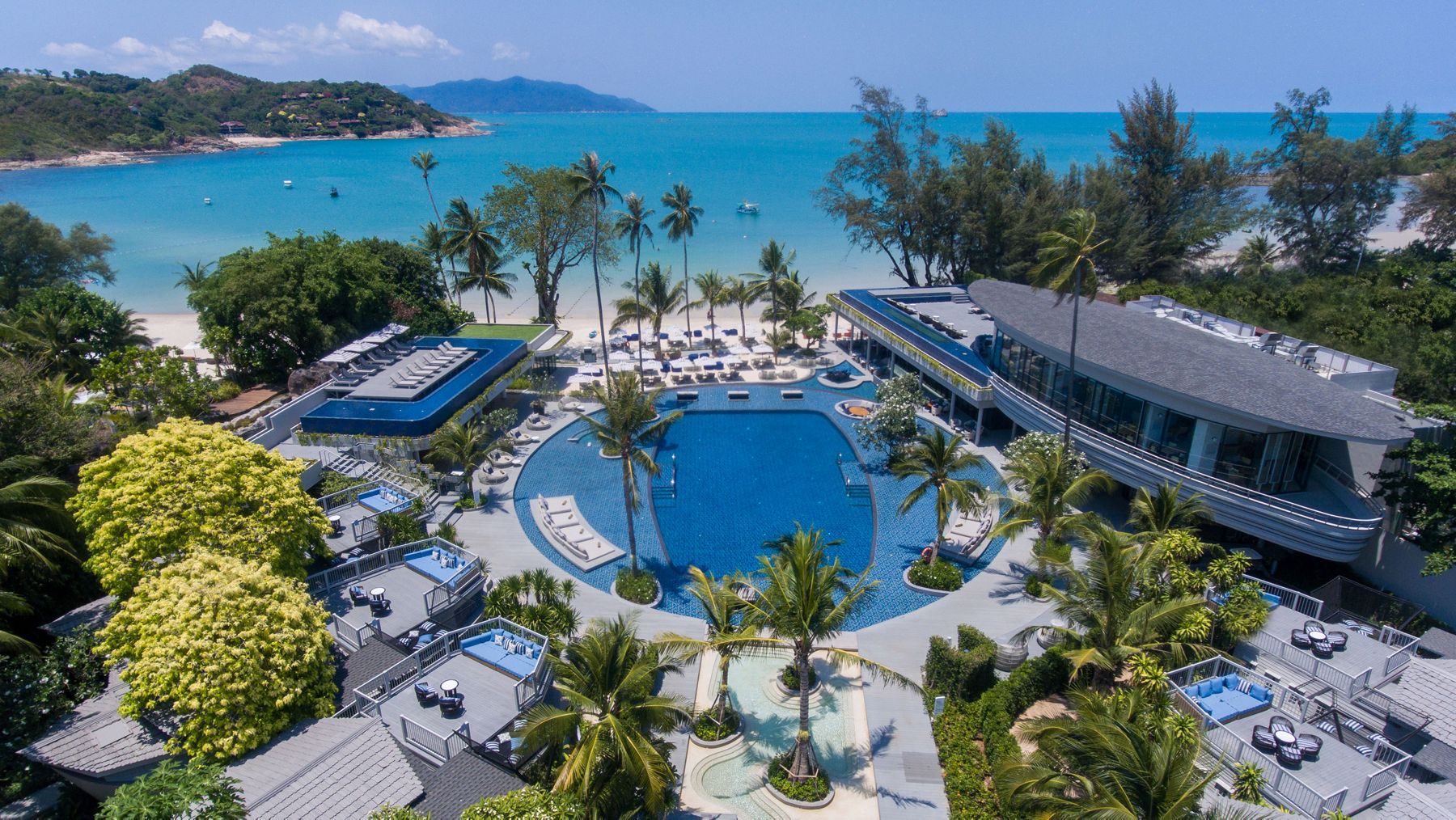 A birdseye view of the Meliá Koh Samui in Thailand, highlighting a large, round pool, cabanas, guest rooms, and lush gardens.