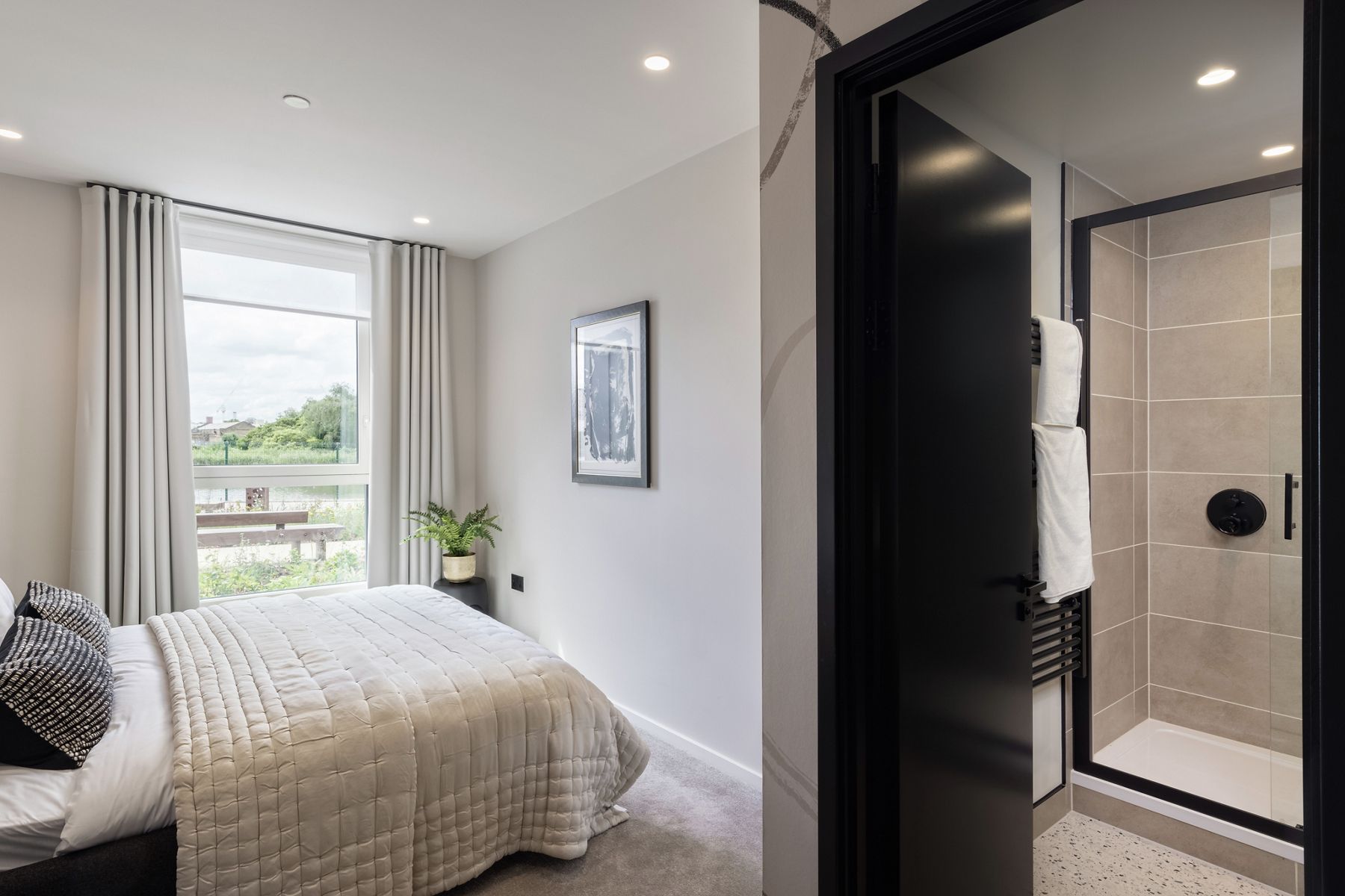 A bed and bathroom in an apartment at the Poplar Riverside in East London.
