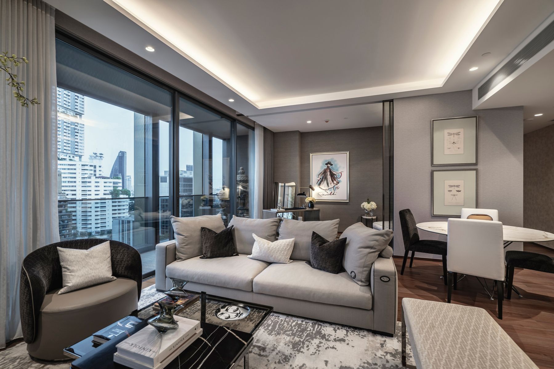 The interior of a condominium at The Estelle Phrom Phong, including a grey couch and beige luxury furniture.