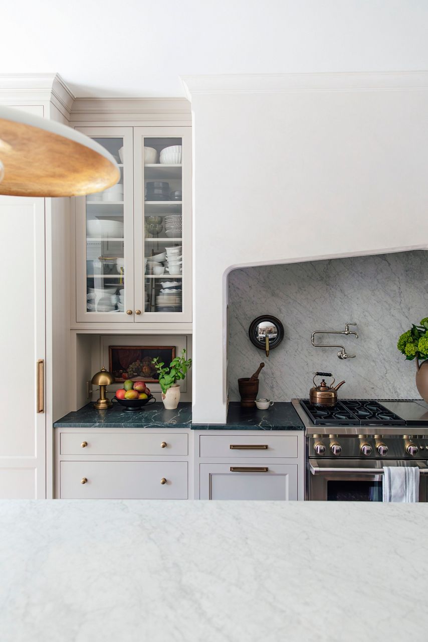 Image of Chris and Julia's kitchen wall, focusing on the oven and decorative range hood where a Kohler pot filler faucet is mounted to the soapstone wall that matches the kitchen island counter top.