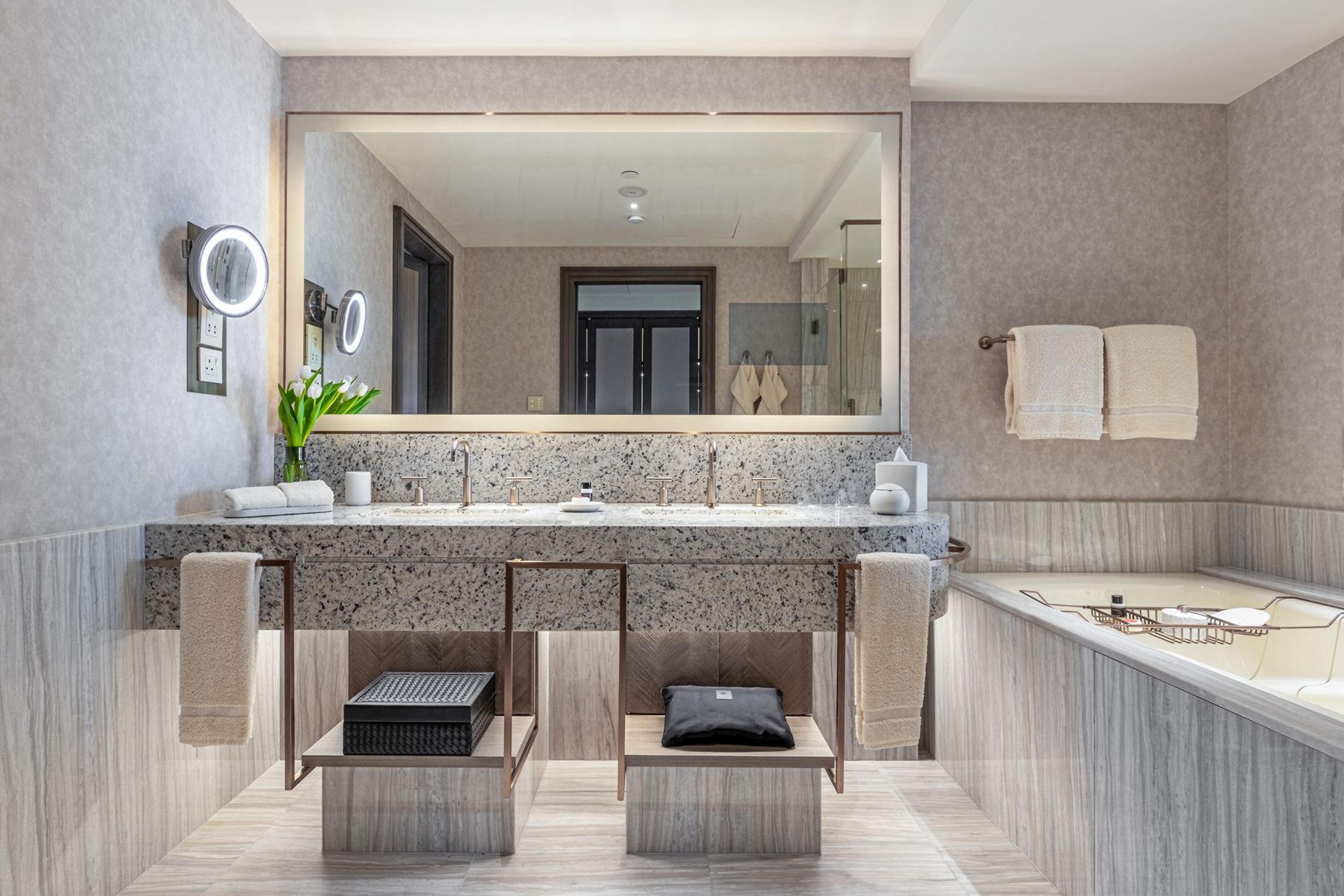 A white and tan guest bathroom in the Four Seasons Hotel Riyadh features double sinks with Purist widespread faucets in Vibrant™ Brushed Bronze finish.