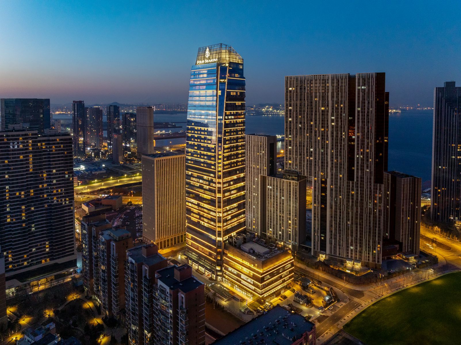 Night view of Four Seasons Hotel Dalian in city centre with ocean background
