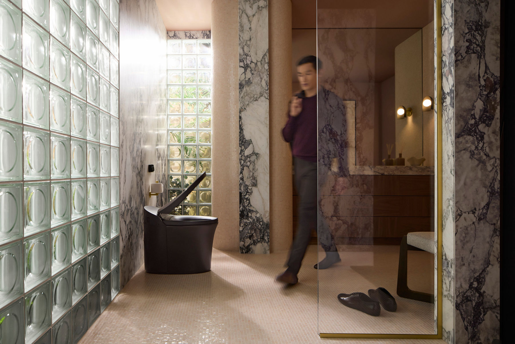 Contemporary bathroom featuring a smart toilet with open lid, marble accents, and glass block window.