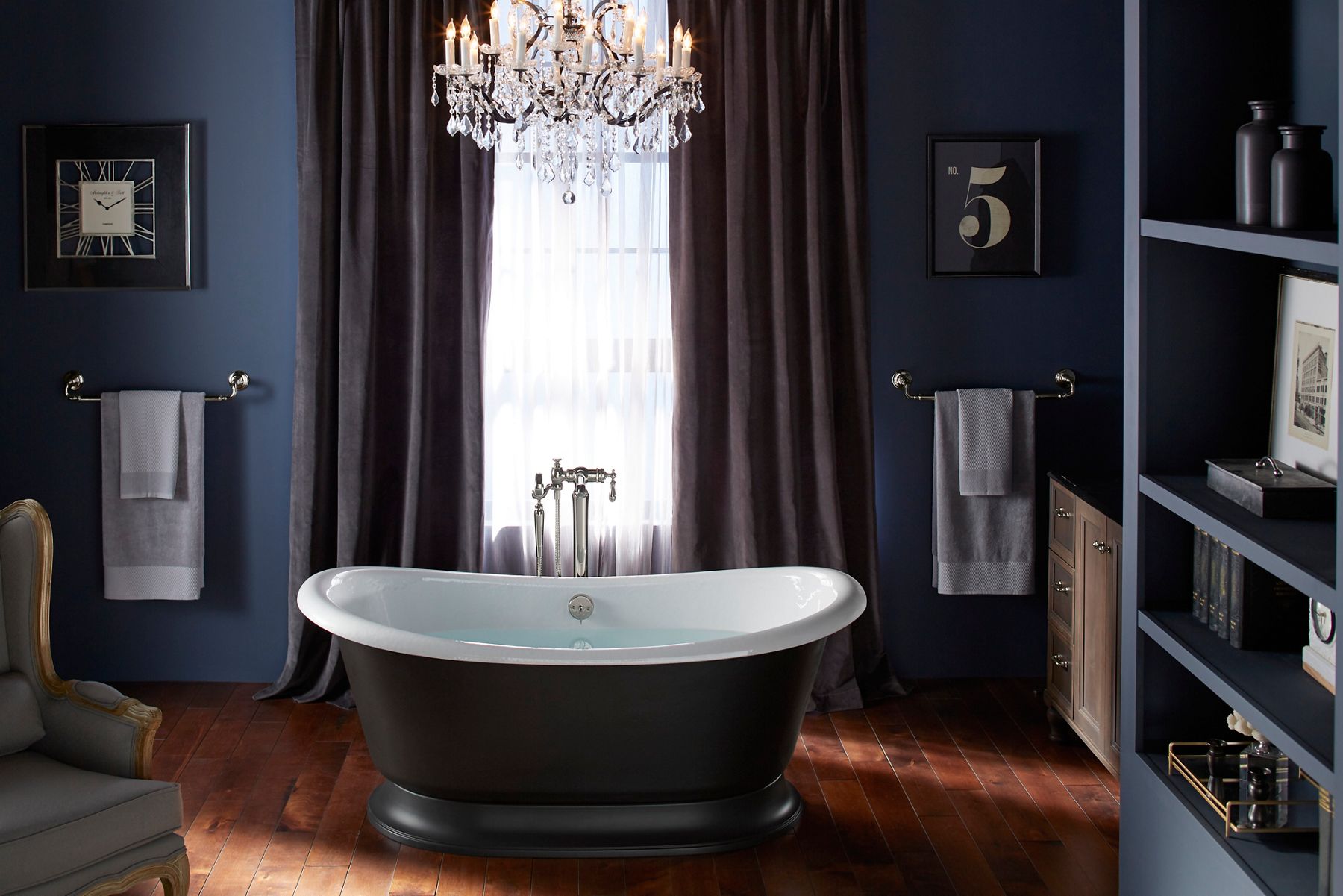 A bathroom in shades of dark indigo with an Artifacts freestanding cast iron bath with a white enameled interior and black exterior in the center.