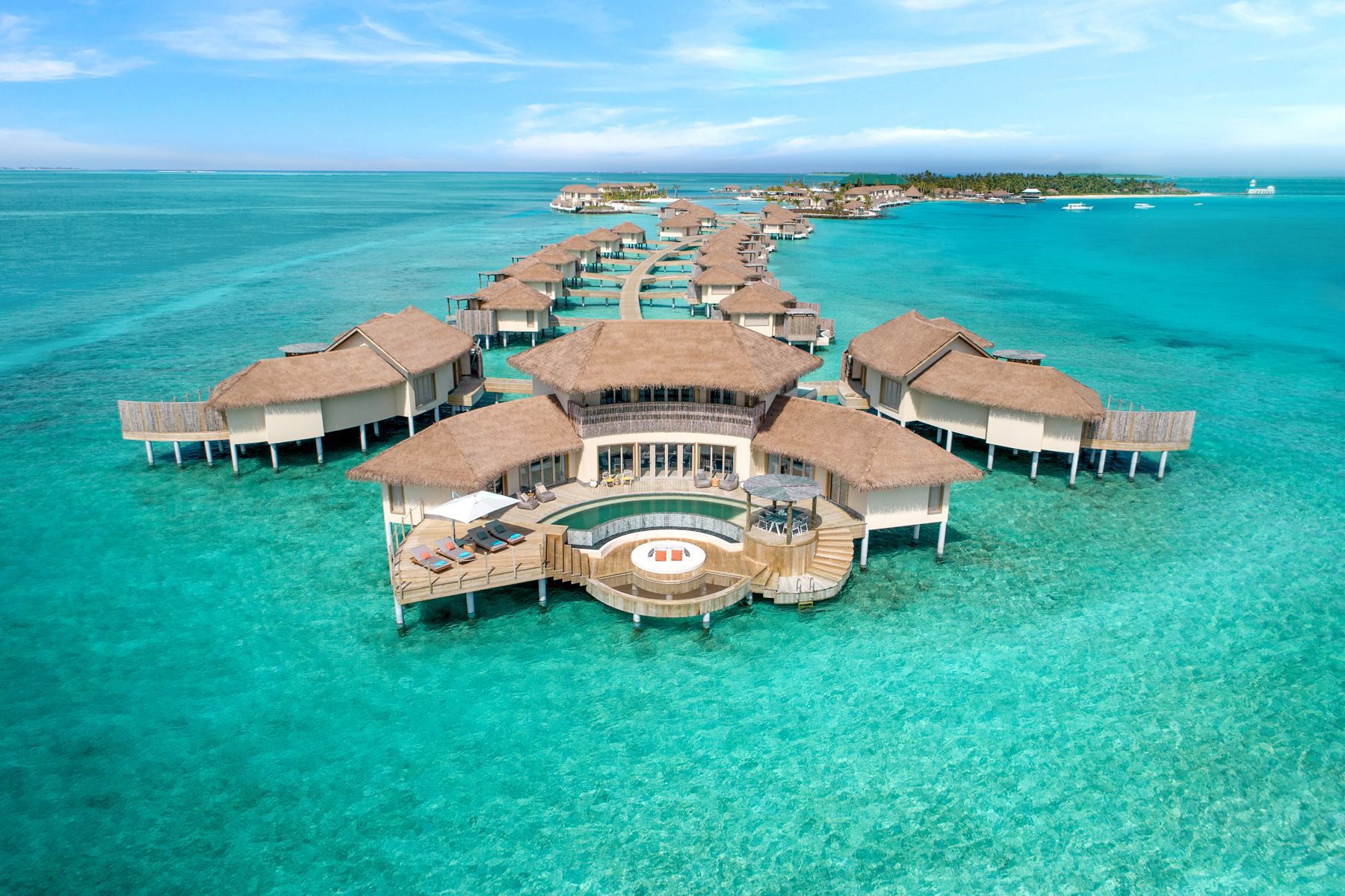A bird’s-eye view of the Intercontinental Maldives Maamunagau Resort with villas surrounded by the ocean.