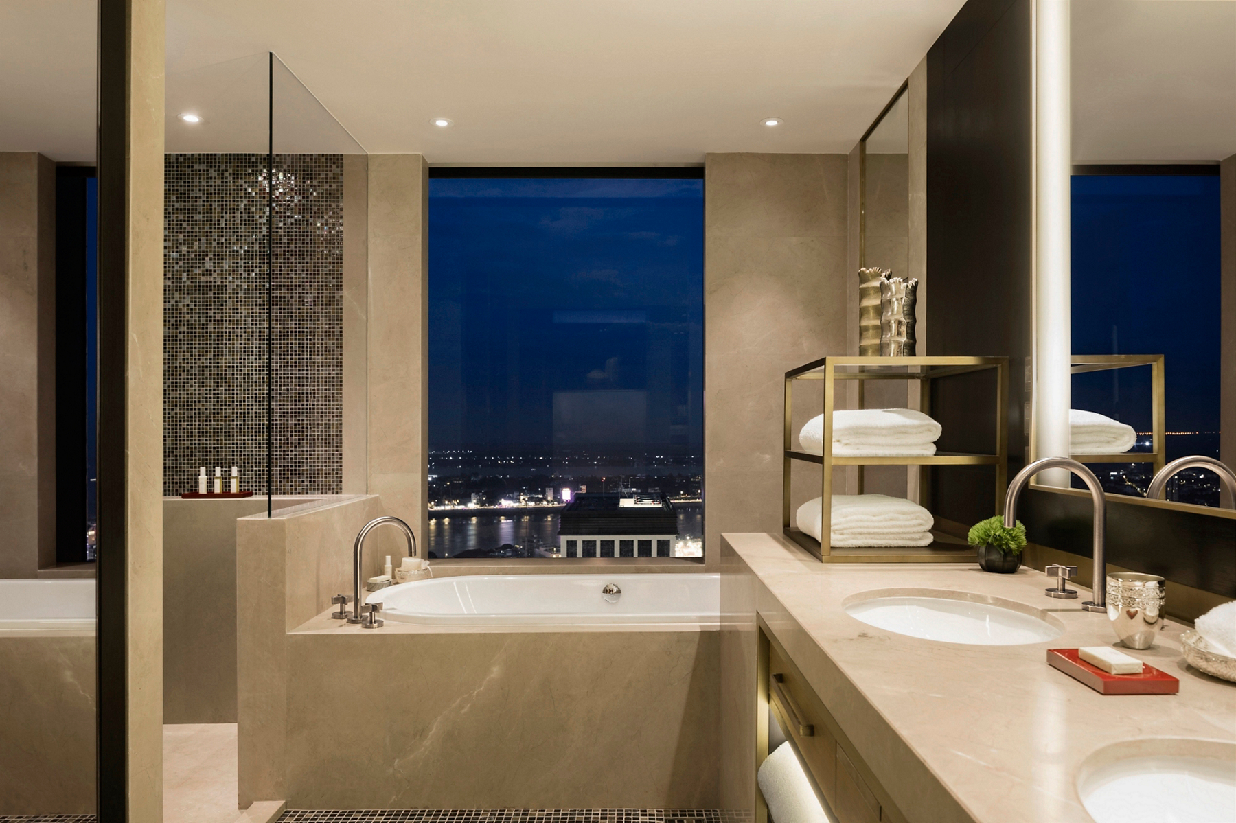 One deck-mount bath faucet with gooseneck spout and cross handles at a drop-in tub