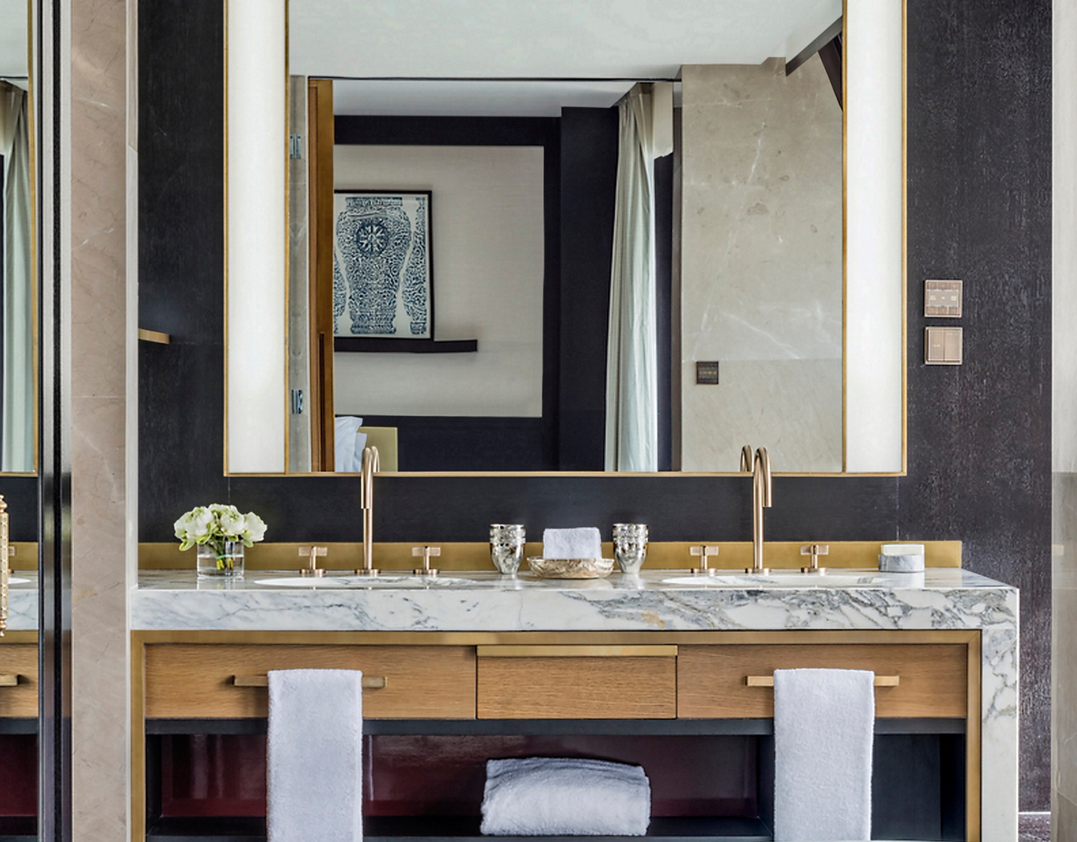 One sink faucets with gooseneck spouts and cross handles on a stone double vanity