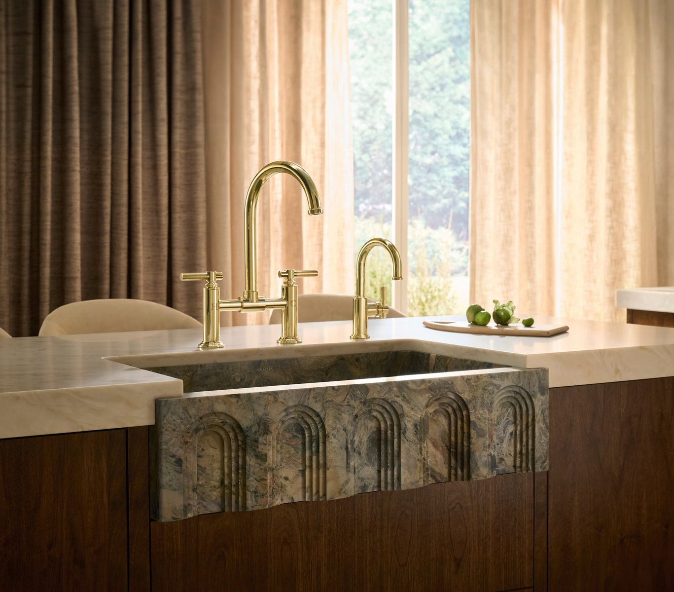 Central Park West bridge kitchen faucet and drinking faucet in Brushed Moderne Brass above a carved Voussoir stone sink.
