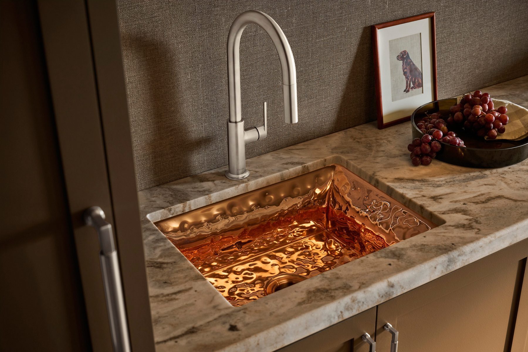 Juxtapose bar faucet in Stainless Steel above a Bacifiore butler sink with a hammered, distressed copper interior.