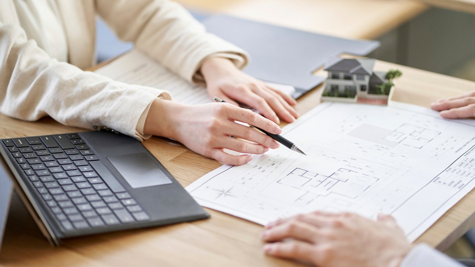 Asian business person having a meeting with the floor plan of real estate