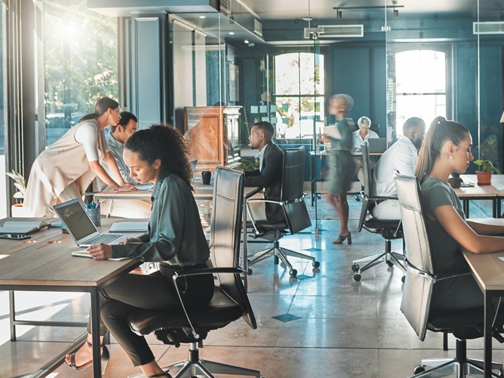 Corporate business people working in busy marketing office space, planning strategy in books and reading email on laptop at work. Businessman, businesswoman and workers at startup advertising company.