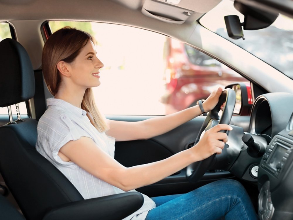 Happy beautiful woman driving modern car