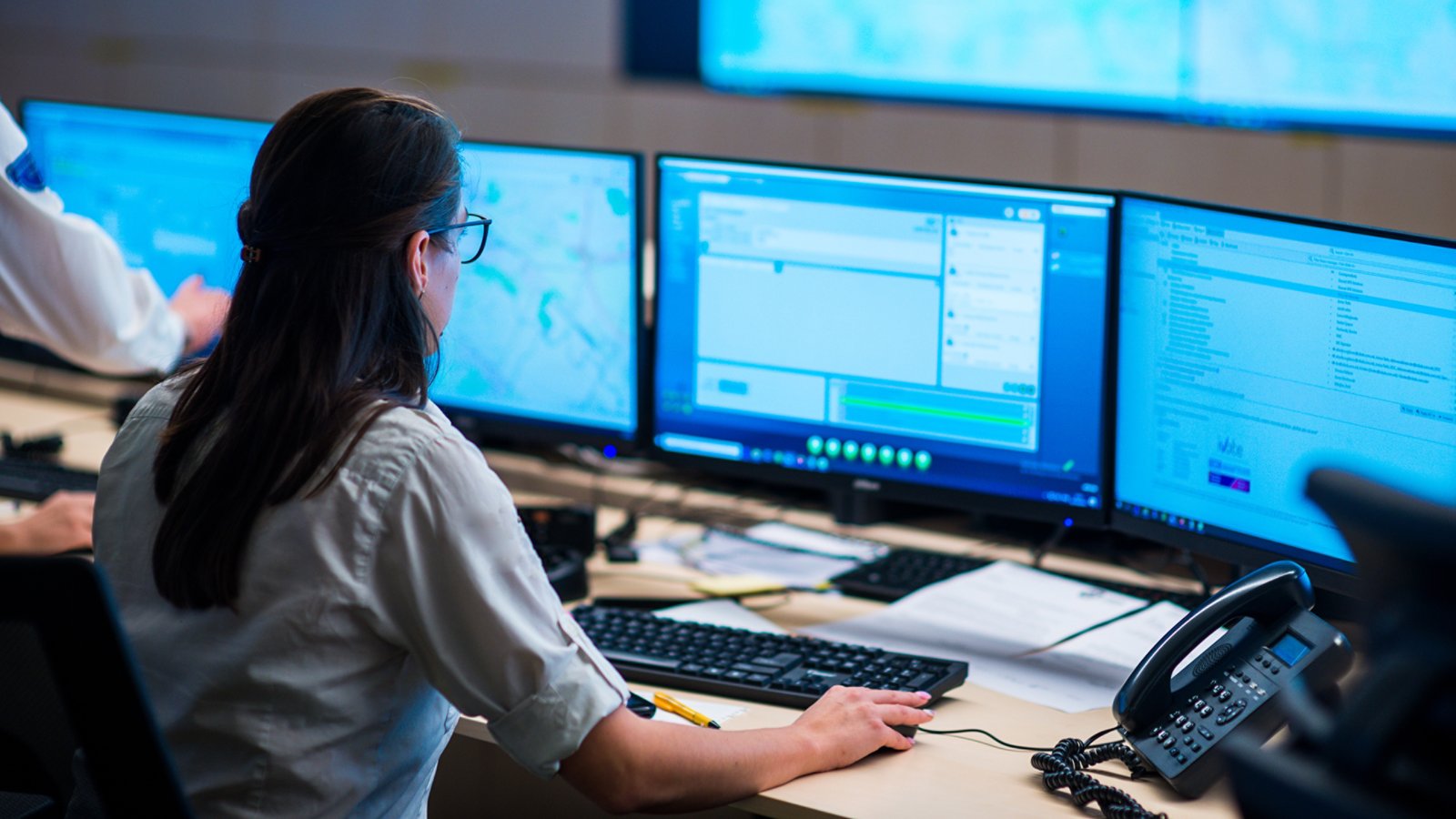 Female security guards working in surveillance room, monitoring cctv and discussing.