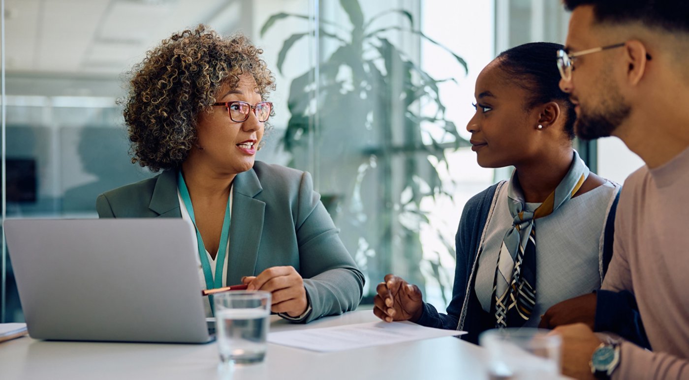 Financial advisor talking to young couple during meeting in office.