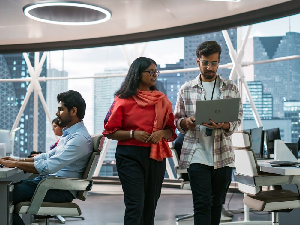 South Asian Specialists Working on Desktop Computers at a Modern Workplace