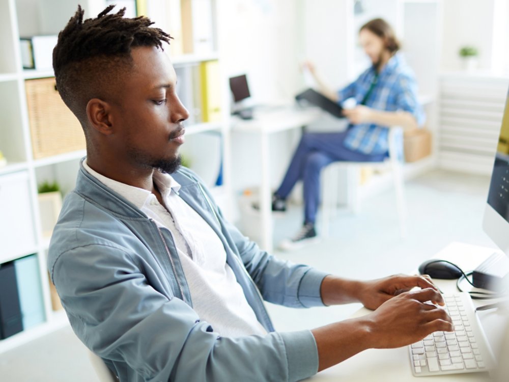 ting by desk, typing and coding data or analyzing new database